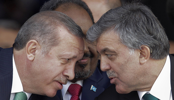 Turkey's President Abdullah Gul (R) and Prime Minister Tayyip Erdogan (L) chat as President of Somalia Hassan Sheikh Mohamud sits between them during the opening ceremony of Marmaray, a subway links Europe with Asia some 60 metres below the Bosphorus Strait, in Istanbul October 29, 2013. Turkey opened the world's first underwater rail link between two continents on Tuesday, connecting Asia and Europe and allowing Prime Minister Tayyip Erdogan to realise a project dreamt up by Ottoman sultans more than a century ago. The engineering feat spans 13 km (8 miles) to link Europe with Asia some 60 metres below the Bosphorus Strait. Called the Marmaray, it will carry subway commuters in Europe's biggest city and eventually serve high-speed and freight trains. REUTERS/Stringer (TURKEY - Tags: POLITICS TRANSPORT BUSINESS) - RTX14SUQ