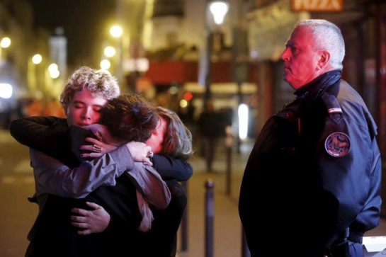 People hug on the street near the Bataclan concert hall following fatal attacks in Paris, France, November 14, 2015. Gunmen and bombers attacked busy restaurants, bars and a concert hall at locations around Paris on Friday evening, killing dozens of people in what a shaken French President described as an unprecedented terrorist attack. REUTERS/Christian Hartmann