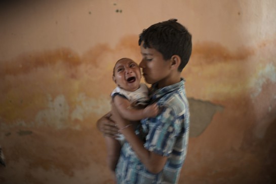 In this Dec. 23, 2015 photo, 10-year-old Elison nurses his 2-month-old brother Jose Wesley at their house in Poco Fundo, Pernambuco state, Brazil. Suspicion of the link between microcephaly and the Zika virus arose after officials recorded 17 cases of central nervous system malformations among fetuses and newborns after a Zika outbreak began last year in French Polynesia, according to the European Center for Disease Prevention and Control. (AP Photo/Felipe Dana)